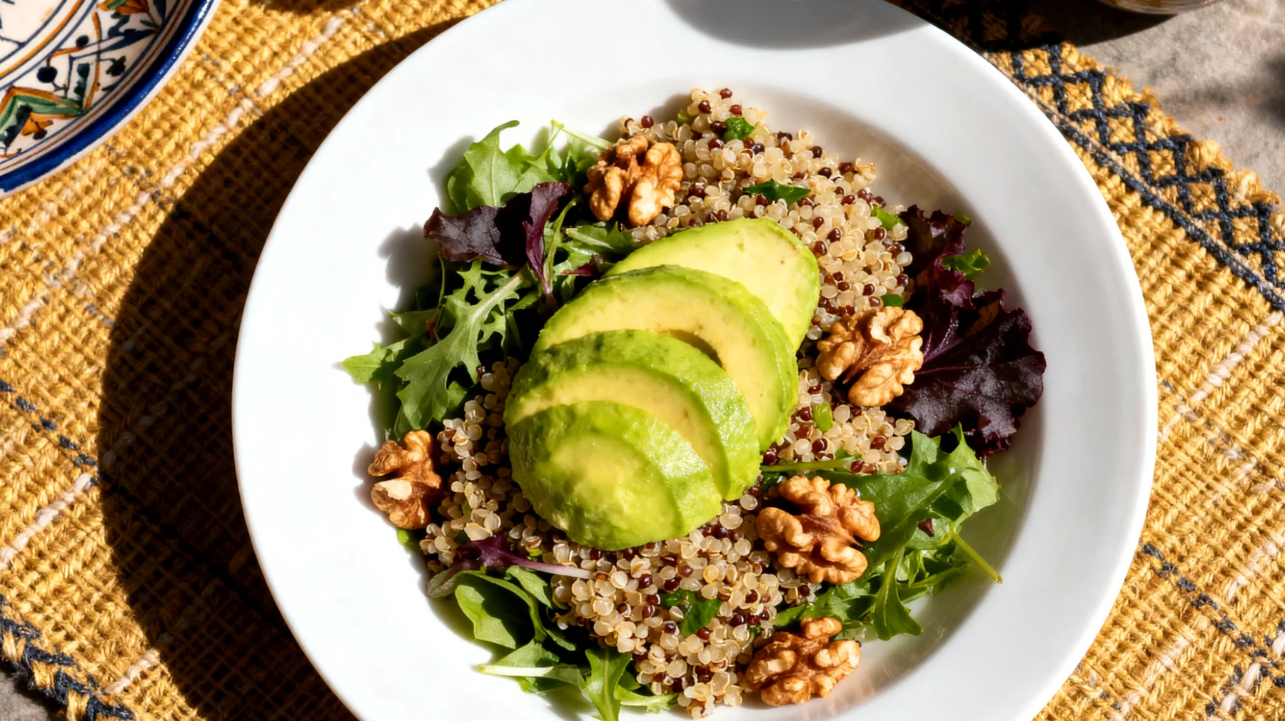 Kinoa salatası ceviz, avokado ve yeşil yapraklı sebzelerle"